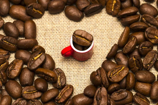 커피 원두와 삼 베 바탕에 컵의 심장 — 스톡 사진