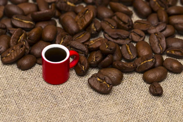 Taza llena de granos de café en el saco de tela —  Fotos de Stock