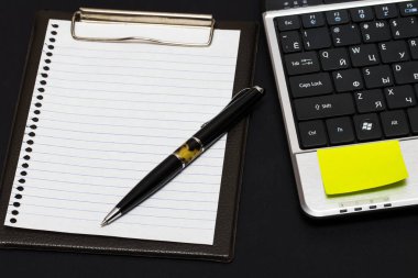 Çalışma alanı: Not defteri ve siyah laptop ile