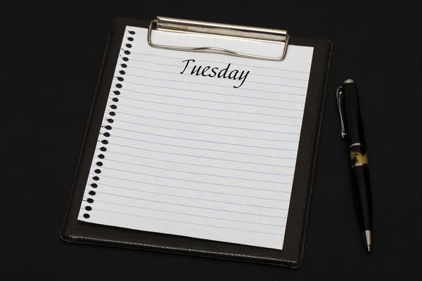 Top view of clipboard and white sheet written with Tuesday on bl — Stock Photo, Image