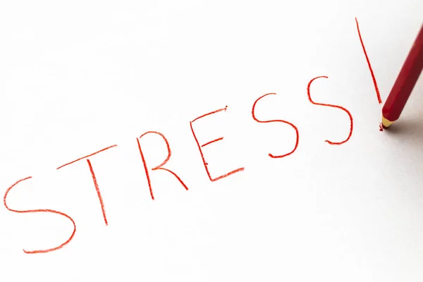 Ein roter Pastellstift, der das Wort "gestresst" schreibt. — Stockfoto
