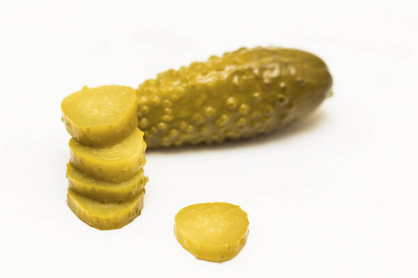Close up of pickled cucumbers and slices isolated on white backg