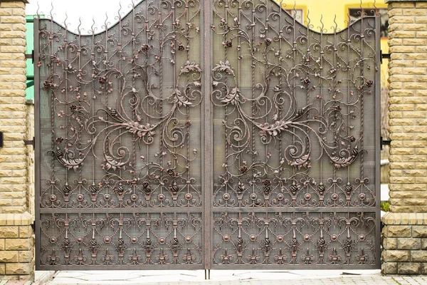 Gates into the courtyard, Gate view from the street, Forged gate — Stock Image Gates into the courtyard, Gate view from the street, Forged gate Royalty Free Stock Images