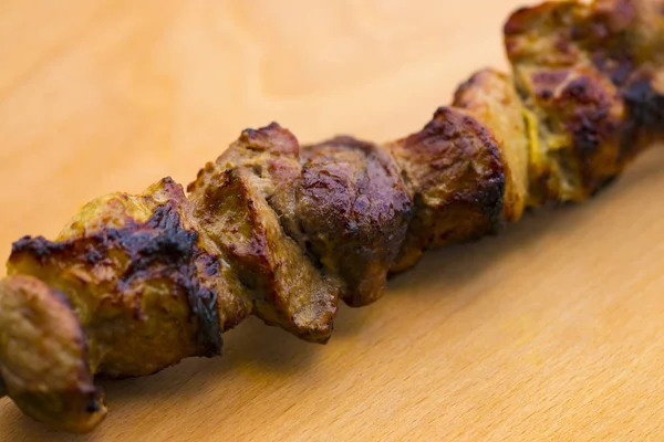 Varkensvlees shish kebab op een houten tafel — Stockfoto