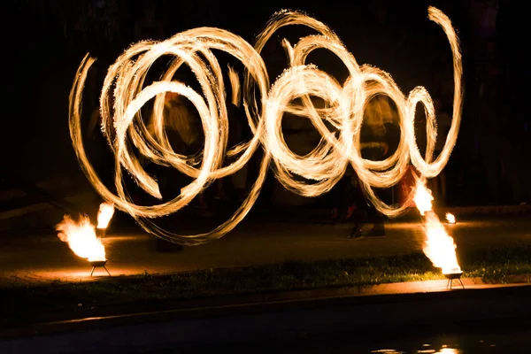 Spectacle de feu et beaucoup d'étincelles lumineuses dans la nuit — Photo