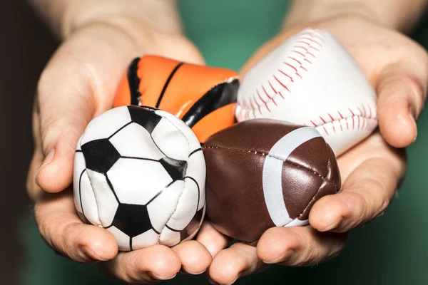 Mãos femininas segurando Coleção de bola esporte com futebol, rugby — Fotografia de Stock