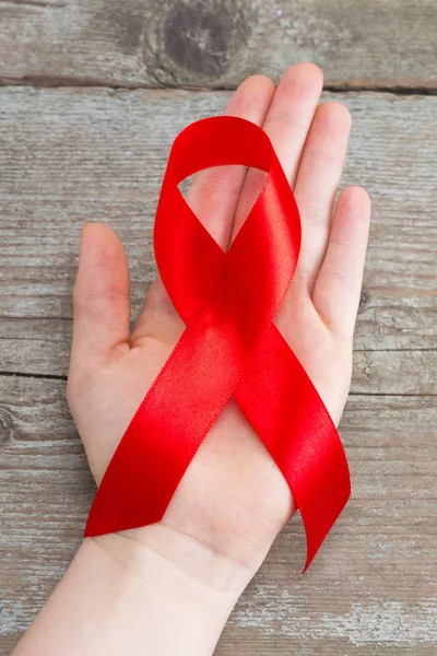 AIDS κόκκινη κορδέλα για τη στήριξη της γυναίκας χέρι κόσμο του aids ημέρα και n — Φωτογραφία Αρχείου