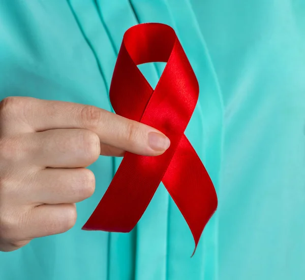 Concepto de salud y medicina - manos femeninas sosteniendo el sida rojo — Foto de Stock