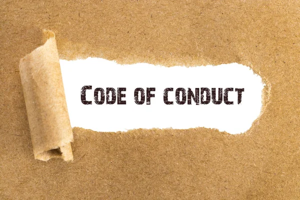 O texto Código de Conduta que aparece atrás do papel castanho rasgado — Fotografia de Stock