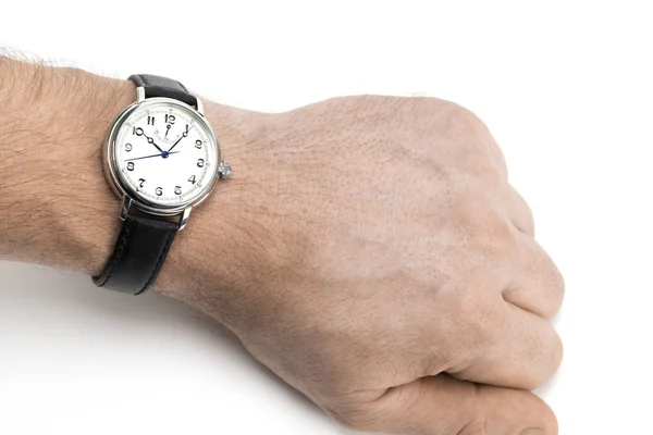 Um homem usando um relógio com pulseira de couro preto sobre uma parte traseira branca — Fotografia de Stock