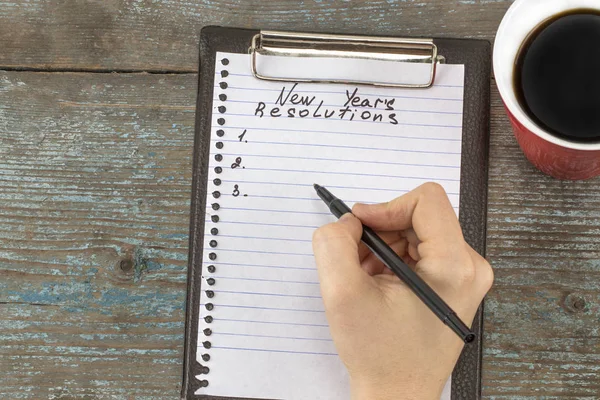 Woman hand writing New Year`s Resolutions. New Year's Resolution — Stock Photo, Image