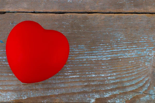 Μια κόκκινη καρδιά σε ξύλινο υπόβαθρο — Φωτογραφία Αρχείου
