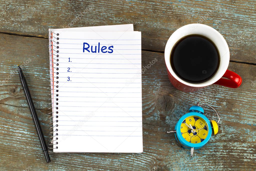  Rules list with notebook, cup of coffee on wooden desk. Top vie