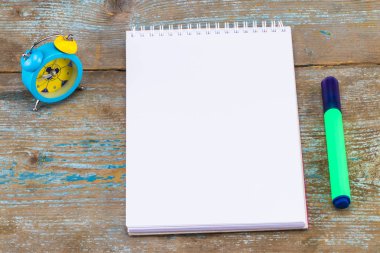 Defter ve çalar saat ahşap arka plan üzerinde. Kopya alanı ile