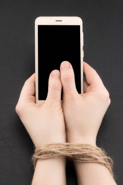 Akıllı telefon veya internet bağımlılığı sicim tarafından bağlı kadın elle