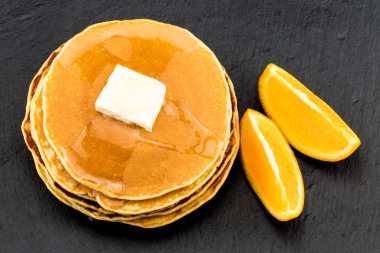 Koyu arka plan üzerine portakal şurubu krep yığını