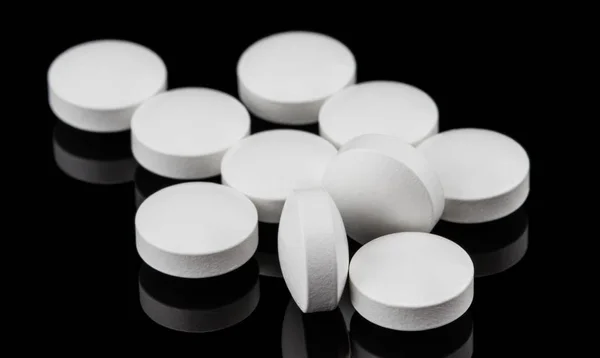 Detailní záběr na skupinu kruhového tvaru bílé pilulky na tmavé pozadí — Stock fotografie