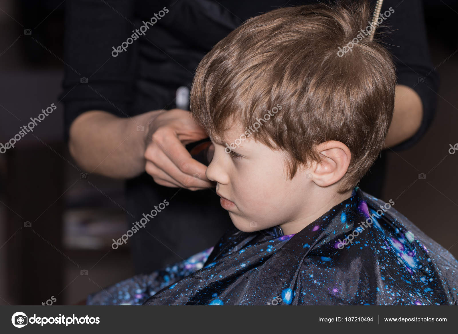 Side View Of Cute Little Boy Getting Haircut By Hairdresser
