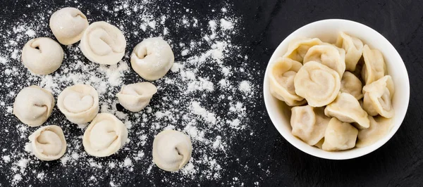 Traditional russian pelmeni, ravioli, dumplings with meat on bla — Stock Photo, Image