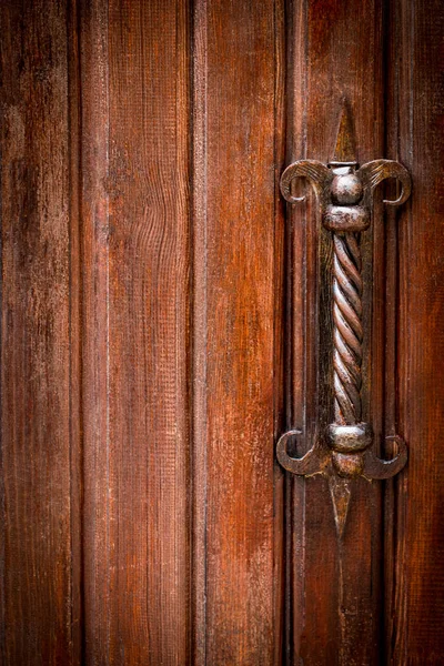 Закрыть старую деревянную дверь металлической отделкой — стоковое фото