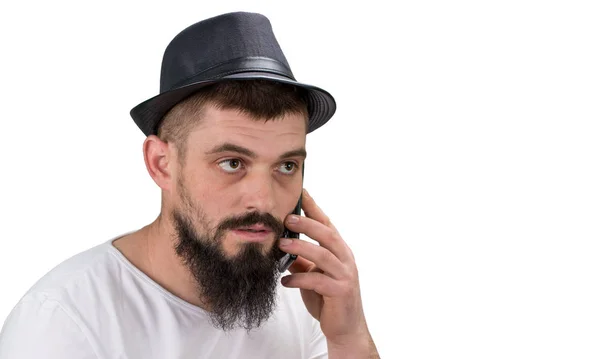 Serous barbudo homem de chapéu falando no telefone isolado no whi — Fotografia de Stock