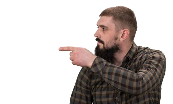 Young bearded hipster pointing away on white background — Stock Photo, Image