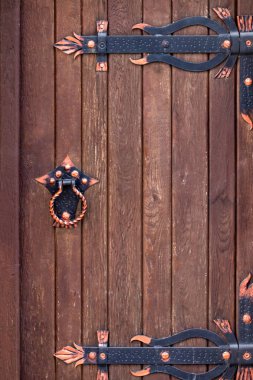 İşlenmiş demir elementli ahşap kapı. Yaklaş.