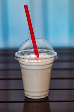 Vanilyalı milkshake üzerinde plastik bardak krem şanti ile kaplı