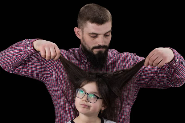 Papai está fazendo seu cabelo filha isolado no fundo preto — Fotografia de Stock