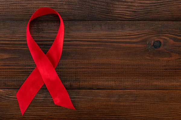 Cinta roja - Símbolo de conciencia del SIDA en el fondo de madera con — Foto de Stock