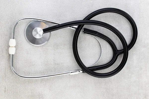 Stethoskop auf grauem Hintergrund. Familiengesundheit, Medizin und — Stockfoto