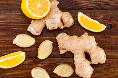 Ahşap arka planda zencefil kökü ve limon, üst manzara 