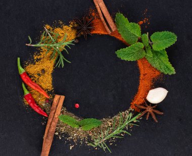 Koyu arkaplanda renkli bitkiler ve baharatlar. Üst görünüm 