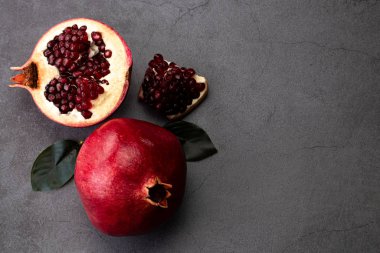 Koyu arkaplanda olgun nar meyveleri, kopyasıyla üstten görünüm