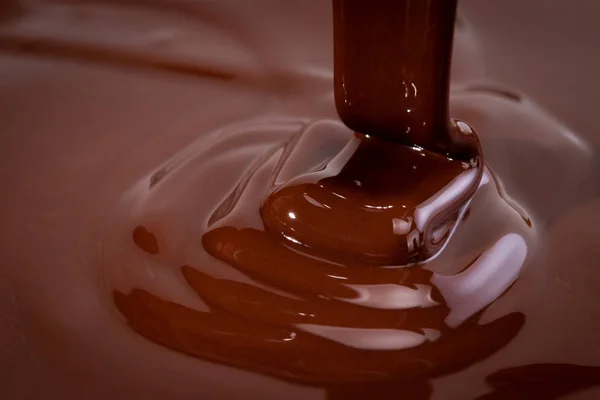 Melted chocolate swirl background. Liquid chocolate close-up
