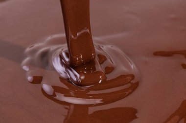 Erimiş çikolata kıvrımlı arka plan. Sıvı çikolata yakın plan.