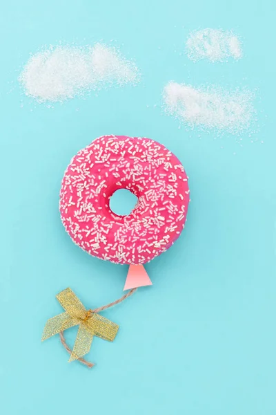 Creative food minimalism. Donut on blue background, donut in a s