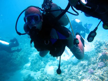 İnsan dalgıcı ve güzel renkli mercan resifi suyun altında.