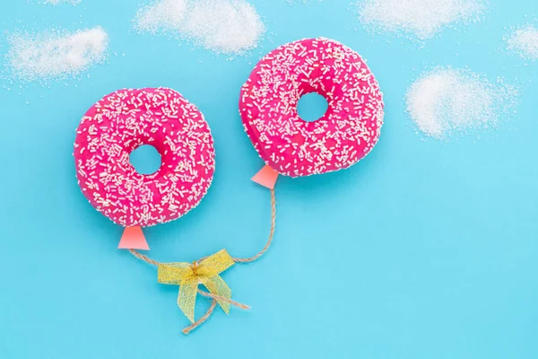 Creative food minimalism. Donut on blue background, donut in a s