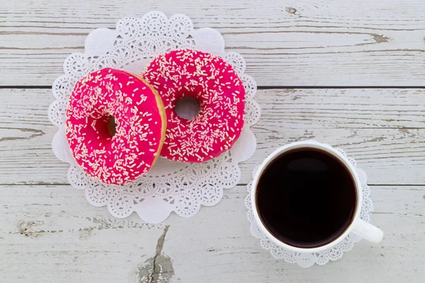 Donuts and coffee on a white wood background, top view — Stock Photo, Image