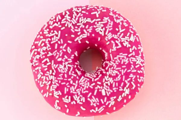 Donut rosa com cobertura em fundo rosa pastel — Fotografia de Stock