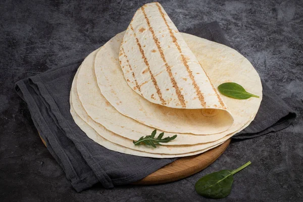 Hromada kukuřičných tortilly na tmavém pozadí. Mexické jídlo — Stock fotografie