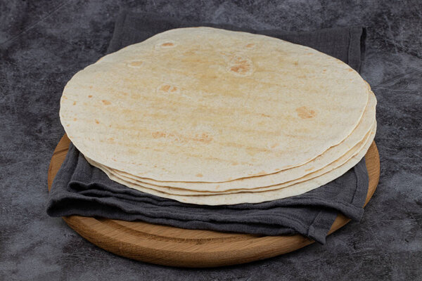 Stack of corn tortillas on dark background. Mexican food