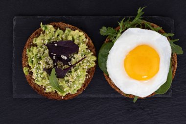 Avokado sandviçi, koyu renkte ıspanaklı ve sahanda yumurtalı çavdar ekmeği..
