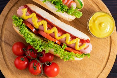 Ahşap arka planda sosisli sandviç. Üst manzara, yemek düzlüğü. Fast food konsepti.