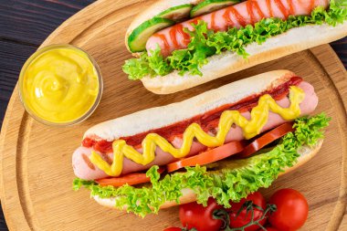 Ahşap arka planda sosisli sandviç. Üst manzara, yemek düzlüğü. Fast food konsepti.