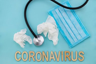Coronavirus konsepti. Tıbbi maske, termometre, steteskop mavi arka planda..