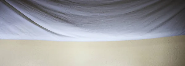 Paño de fondo doblado drapeado contra la pared — Foto de Stock