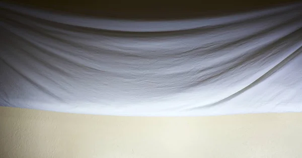 Piegato drappeggiato panno sfondo contro parete — Foto Stock