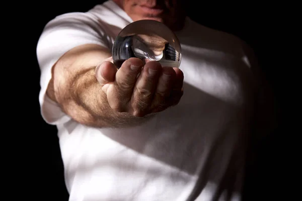 Man in white holding out crystal ball — Stock Photo, Image